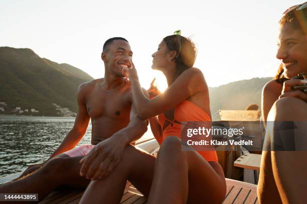 young woman applying sunscreen on man's nose - bronzage humour photos et images de collection