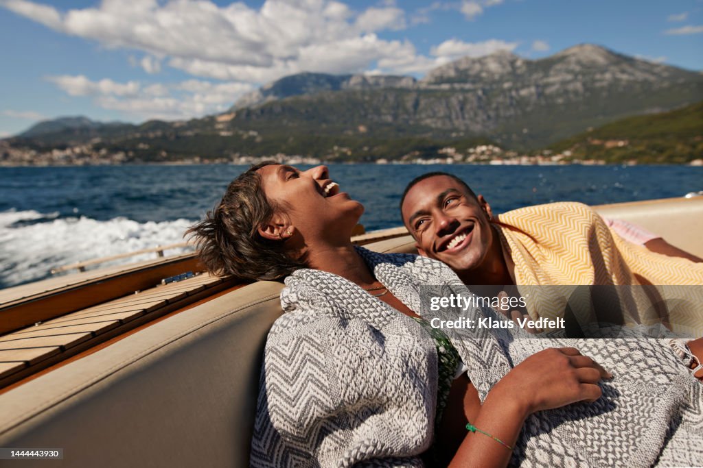 Young man and woman laughing in speedboat