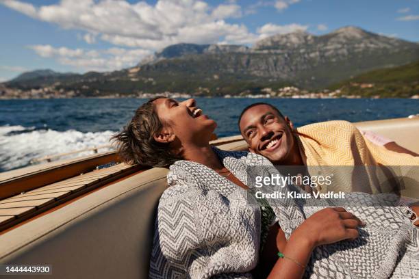 young man and woman laughing in speedboat - travel fotografías e imágenes de stock