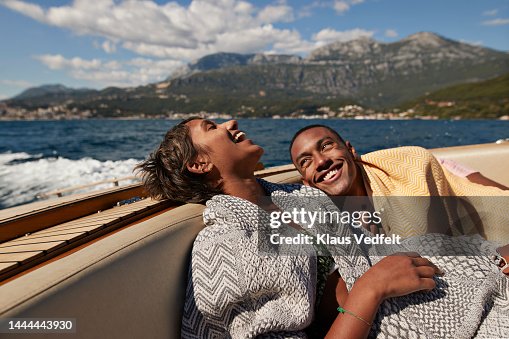 Young man and woman laughing in speedboat Young man and woman laughing in speedboat