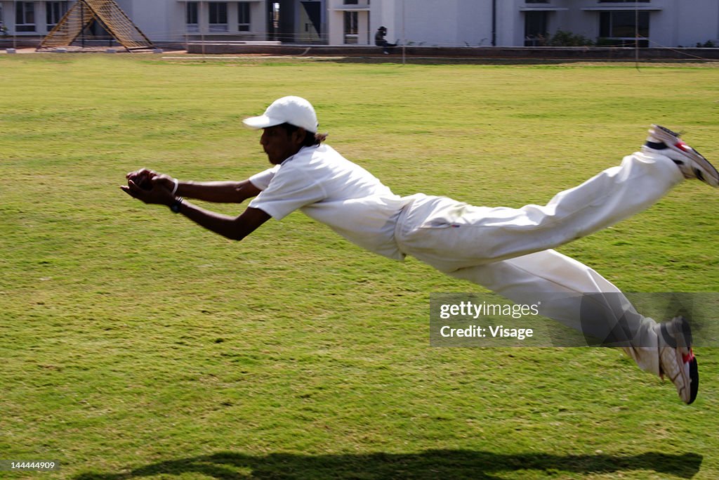 A fielder diving to take a catch