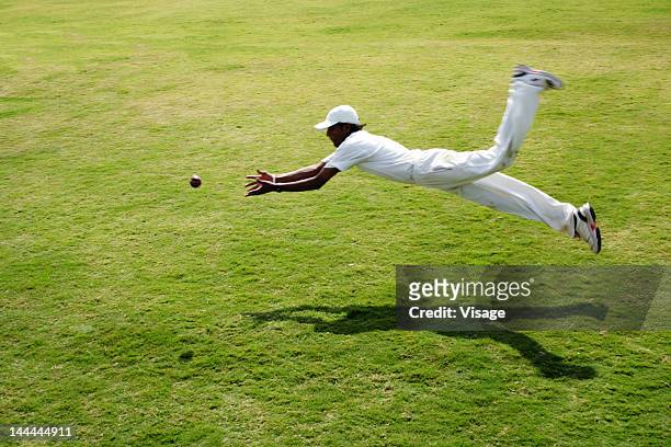 a fielder diving to take a catch - cricket catch ストックフォトと画像