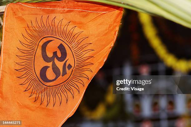 a saffron coloured cloth with a an om symbol on it - om teken stockfoto's en -beelden