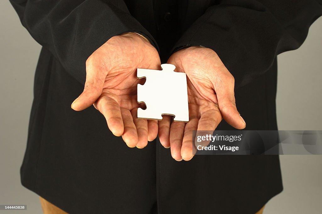 Close up of a person holding a puzzle piece