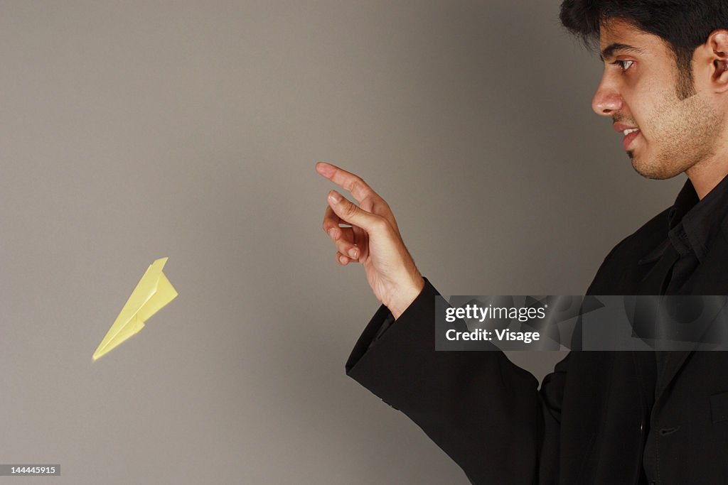 A businessman throwing a paper plane