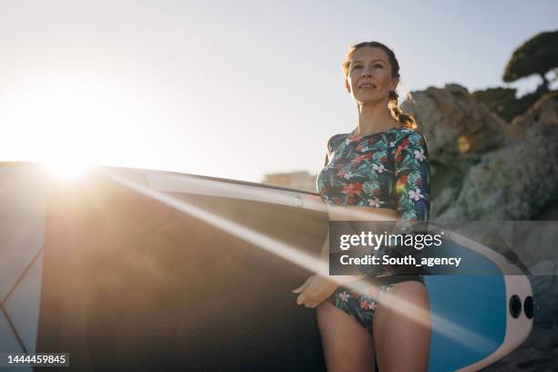 surfer on the beach - mature surfers stock pictures, royalty-free photos & images