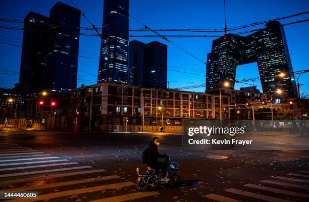 Man wears a mask to prevent the spread of COVID-19 as he waits in a nearly empty intersection near the Central Business District during rush hour on...