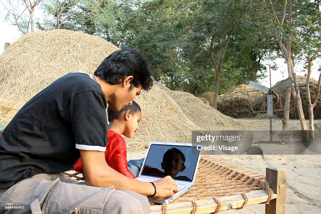 Father and son working on laptop
