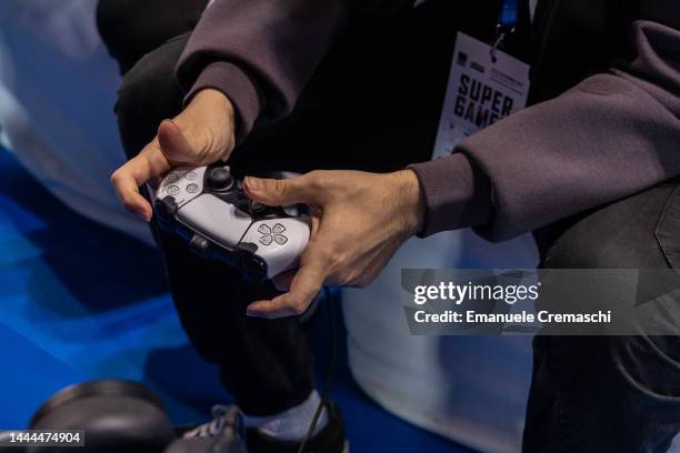 Man uses a Playstation gamepad during Milan Games Week & Cartoomics 2022 at Fiera Milano Rho on November 25, 2022 in Milan, Italy. Milan Games Week &...