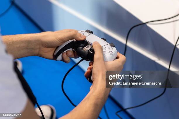 Man uses a Playstation gamepad during Milan Games Week & Cartoomics 2022 at Fiera Milano Rho on November 25, 2022 in Milan, Italy. Milan Games Week &...