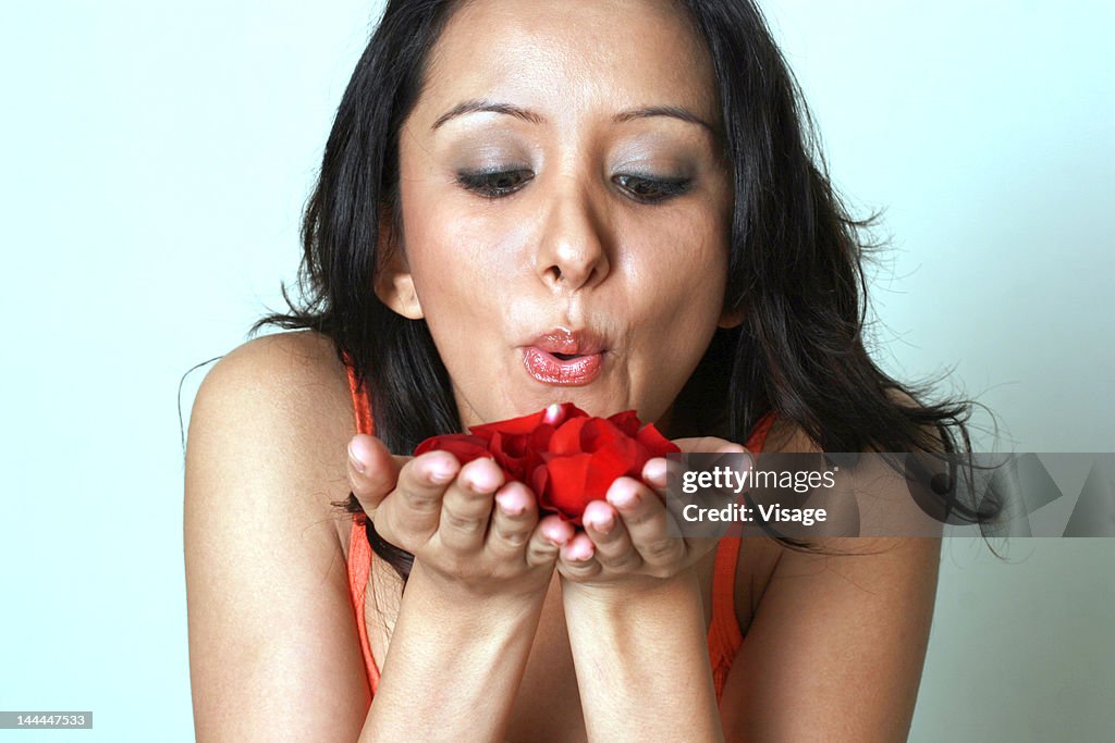 A woman holding rose petals in her hands