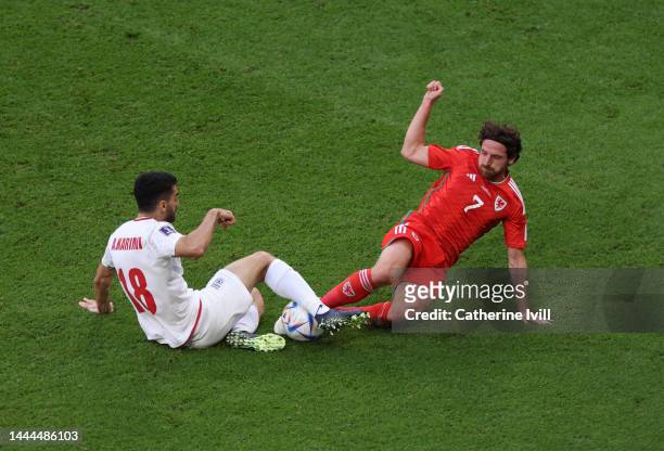 Joe Allen of Wales tackles Ali Karimi of IR Iran during the FIFA World Cup Qatar 2022 Group B match between Wales and IR Iran at Ahmad Bin Ali...