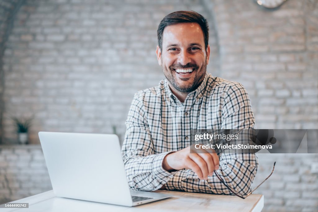 Successful businessman in modern office working on laptop.