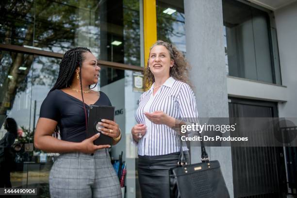 des femmes d’affaires parlent devant le travail - mulheres maduras photos et images de collection