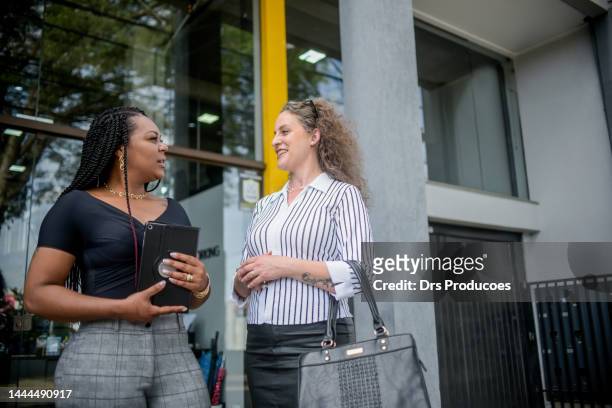 businesswomen talking in front of work - negócio empresarial bildbanksfoton och bilder