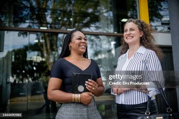 businesswomen talking in front of work - negócio empresarial bildbanksfoton och bilder