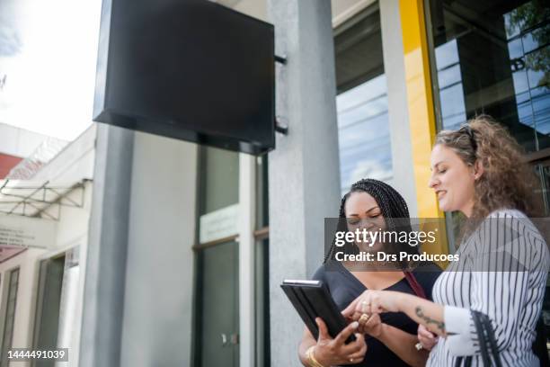 des femmes d’affaires parlent devant le travail - gerente photos et images de collection