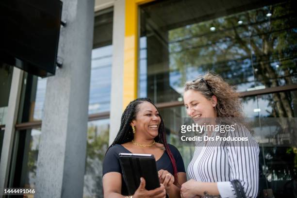 businesswomen talking in front of work - gerente stockfoto's en -beelden