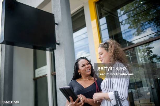 des femmes d’affaires parlent devant le travail - mulheres maduras photos et images de collection