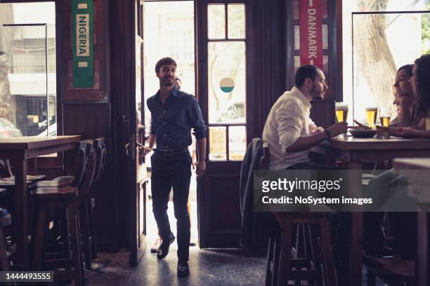 friend watching soccer, drinking beer in the bar - bar atmosphere stock pictures, royalty-free photos & images
