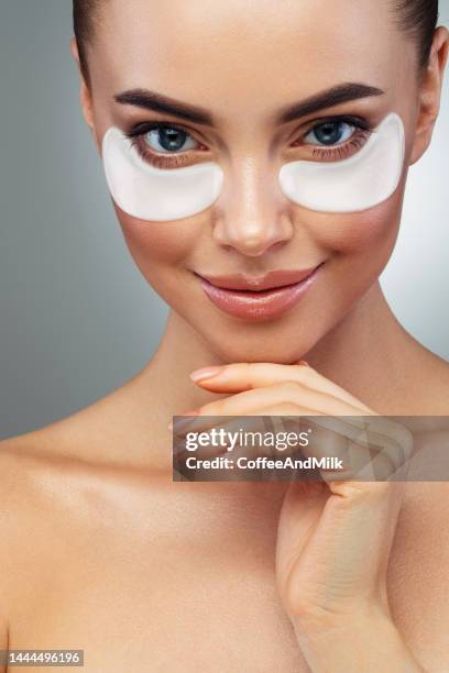 woman with eye patches under her eyes - medical eye patch stockfoto's en -beelden