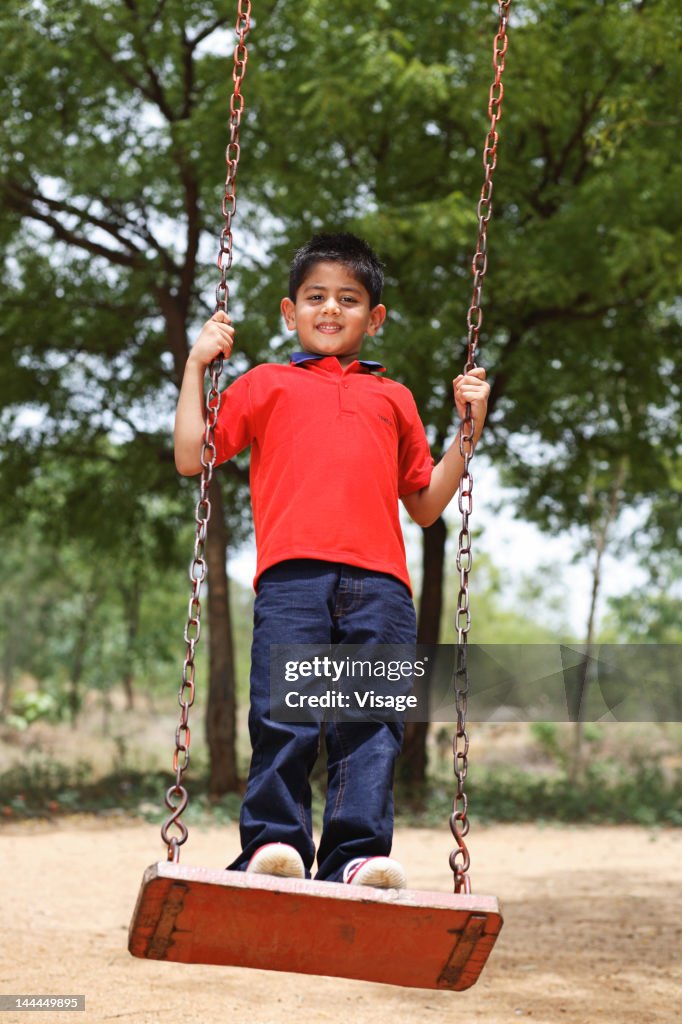 View of a young boy playing on a swing