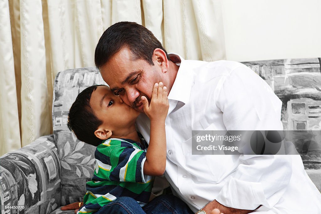 A boy kissing his father