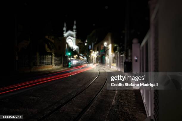 bright skid in the street between the houses with tram track at night - train yard at night stock pictures, royalty-free photos & images