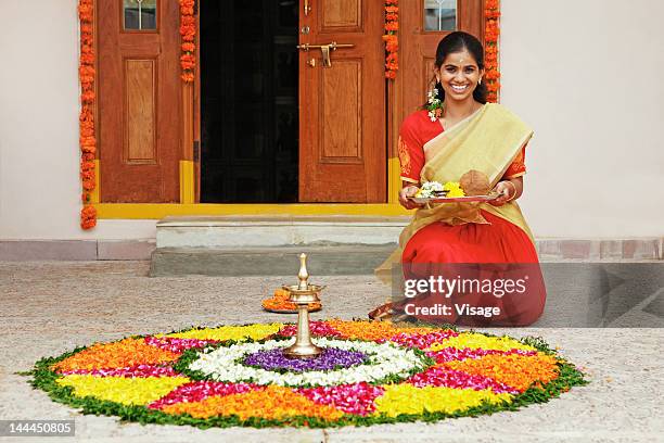 woman next to a pookalam - onam stock pictures, royalty-free photos & images