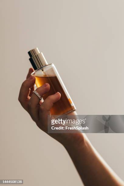 anonymous woman holding a bottle of perfume - 香水 個照片及圖片檔