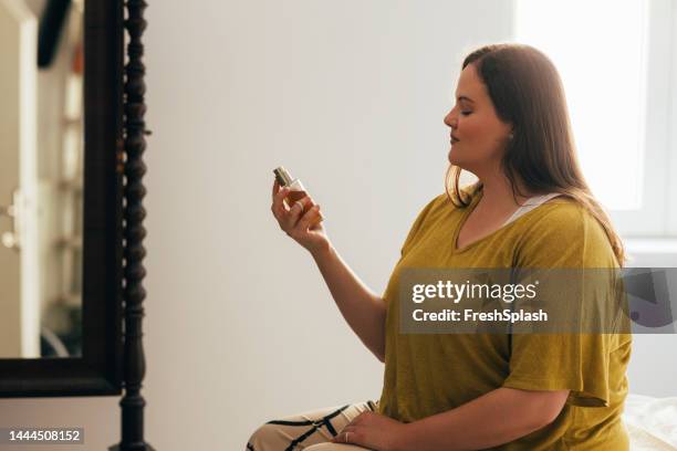overweight woman holding a perfume bottle - made up bed stock pictures, royalty-free photos & images