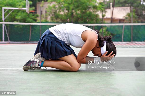 young woman kneeling on a tennis court - focus on sport 2012 stock pictures, royalty-free photos & images