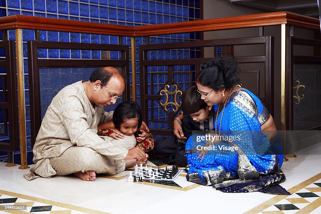 Children watching their grandparents playing chess