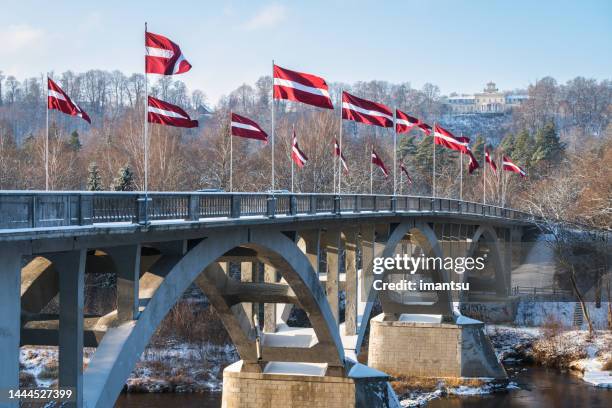banderas estatales letonas en el puente gaujas en invierno - letonia fotografías e imágenes de stock