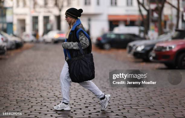 Sonia Lyson is seen wearing black VeeCollective Caba bag, New Balance grey jogging pants, New Balance white 530 sneaker, Lala Berlin black and white...