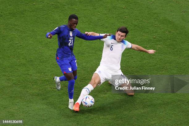 Timothy Weah of United States battles for possession with Harry Maguire of England during the FIFA World Cup Qatar 2022 Group B match between England...