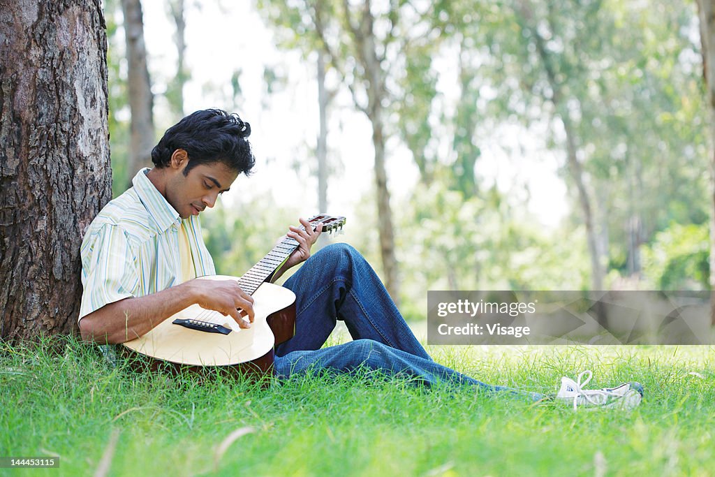 Man playing guitar in a park