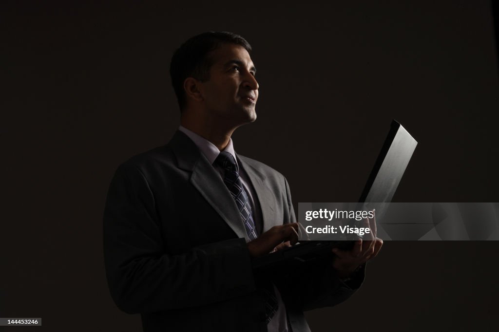 Portrait of a businessman holding a laptop