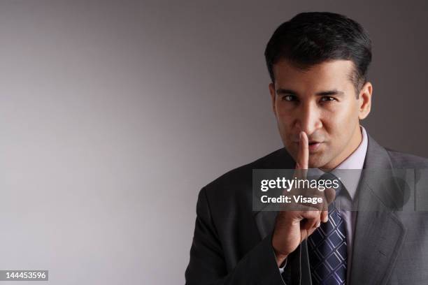 a businessman holding finger to lips, portrait - visage close up stock pictures, royalty-free photos & images