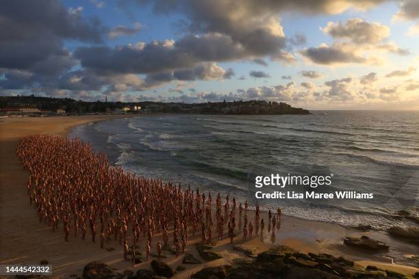 Members of the public pose at sunrise for photographic artist Spencer Tunick at Bondi Beach on November 26, 2022 in Sydney, Australia. US artist and...