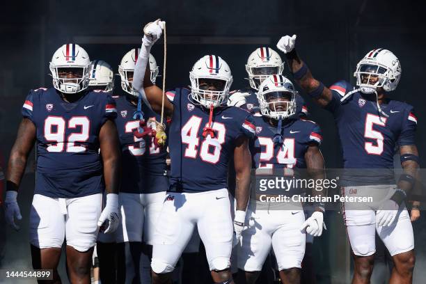 Kyon Barrs, Jerry Roberts, Jai-Ayviauynn Celestine and Christian Young of the Arizona Wildcats walk out onto the field before the NCAAF game against...