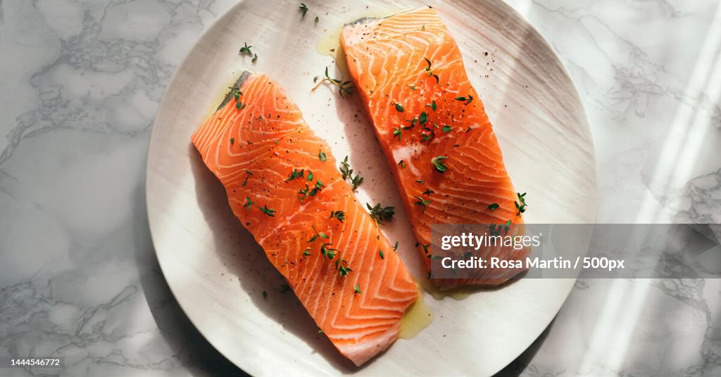 High angle view of salmon slice with herbs on plate on table,Egypt