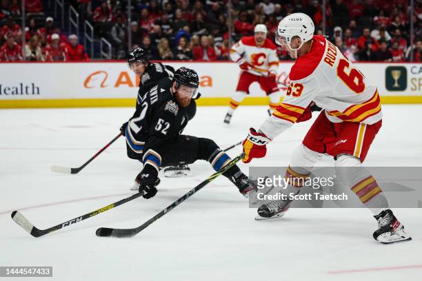 Adam Ruzicka of the Calgary Flames looks to shoot the puck as Matt Irwin of the Washington Capitals defends during the third period of the game at...