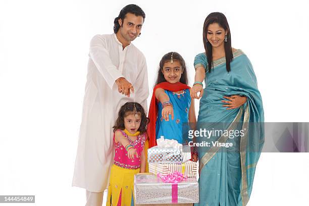 portrait of a family showing diwali gifts - indian girl pointing stock-fotos und bilder