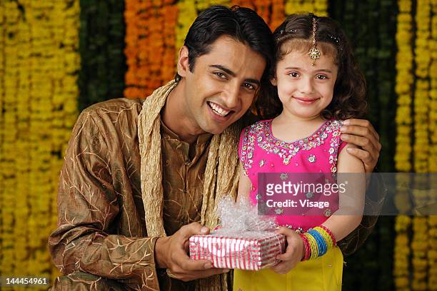 portrait of a father and daughter holding a gift box - visage close up stock pictures, royalty-free photos & images
