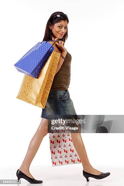 young woman holding shopping bags and walking - visage close up stock pictures, royalty-free photos & images