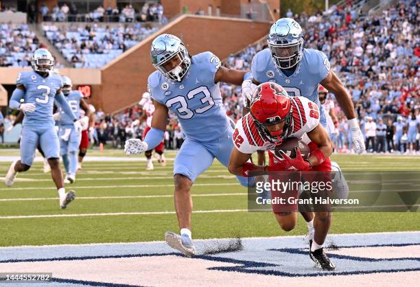 Terrell Timmons Jr. #82 of the North Carolina State Wolfpack makes a touchdown catch against Cedric Gray and Cam'Ron Kelly of the North Carolina Tar...