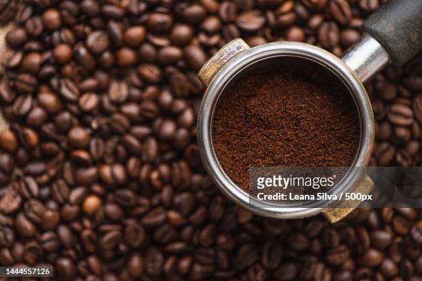 top view of ground coffee in portafilter on coffee beans background,united states,usa - coffee maker stock pictures, royalty-free photos & images