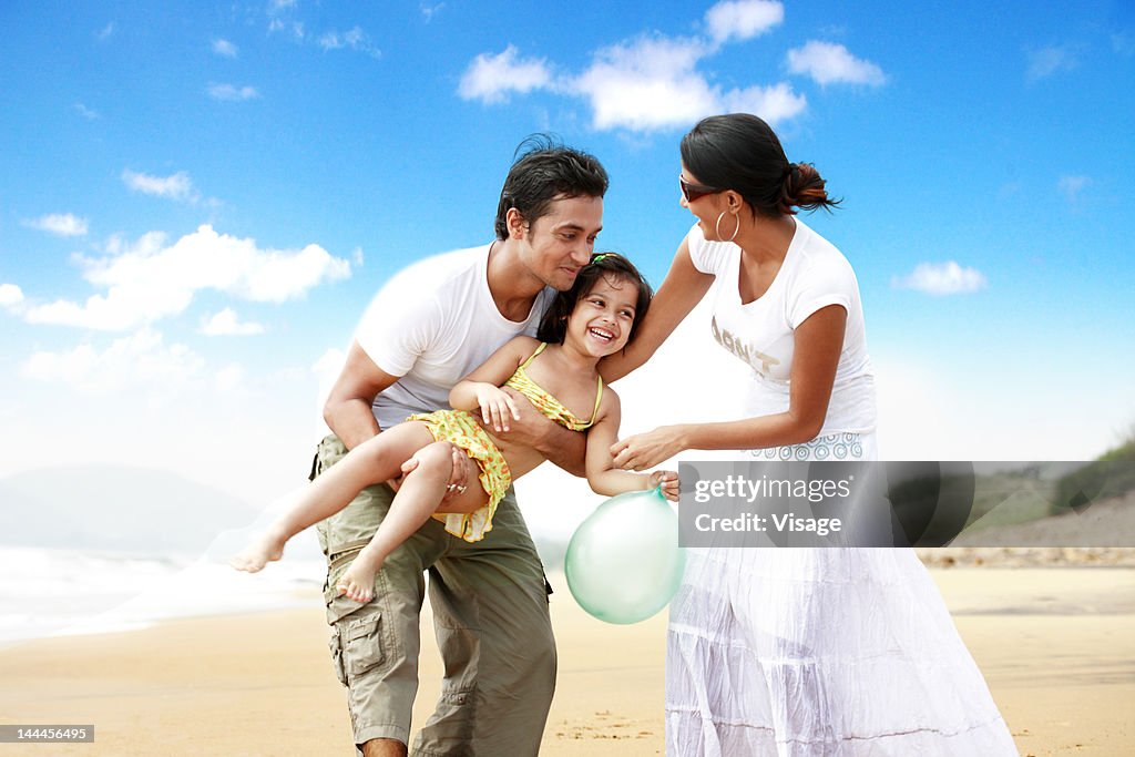 Couple at a beachside with their daughter