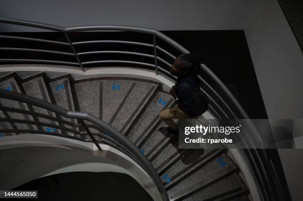 hombre de negocios subiendo una escalera - trabalho comercial fotografías e imágenes de stock